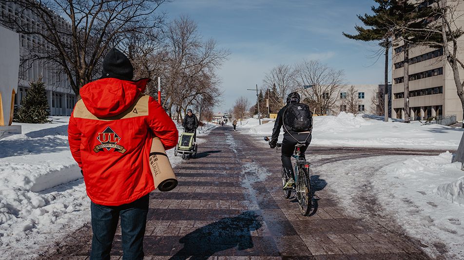 Piéton et cycliste qui se déplacent aisément sur le campus déneigé